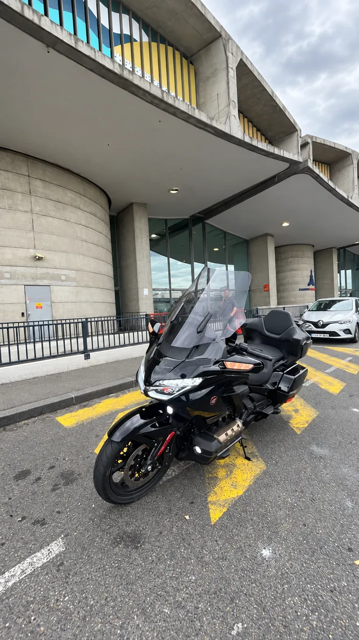 La Honda Gold Wing noire garée devant un terminal de l'aéroport Roissy-Charles de Gaulle